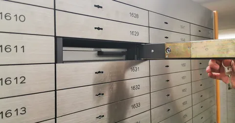 Eine Wand mit Bankschließfächern. Eins ist geöffnet.
