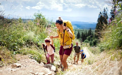 Familie mit zwei Kindern wandert einen Bergpfad hinauf