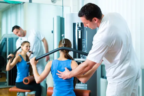 Physiotherapeut und Patientin während einer Rückenübung