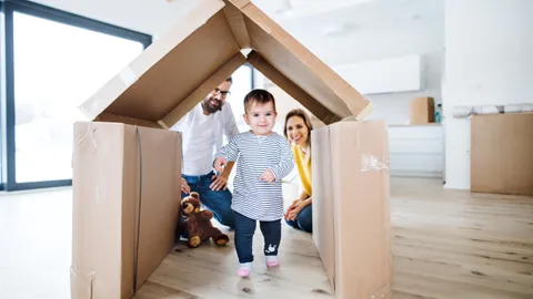 Kleinkind läuft durch ein Pappkarton-Haus