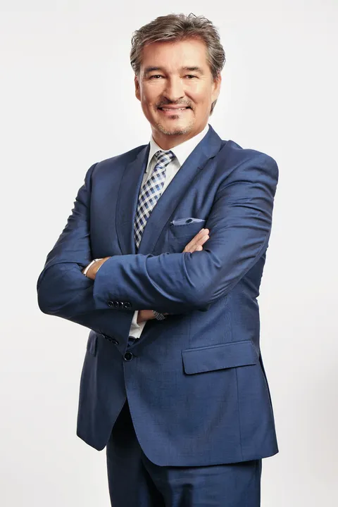 Agenturinhaber Reinhard Hartig lachend und mit verschränkten Armen. 