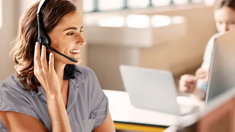 Eine Frau mit Headset telefoniert.