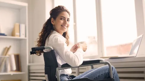 Lächelnde Frau sitzt mit Kaffeetasse in einem Rollstuhl.