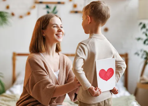 Junge mit Liebesbrief hinter dem Rücken