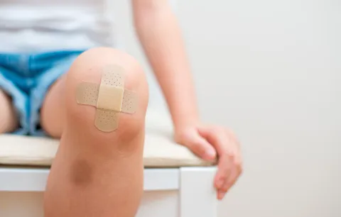 Ein Kinderknie mit Pflaster