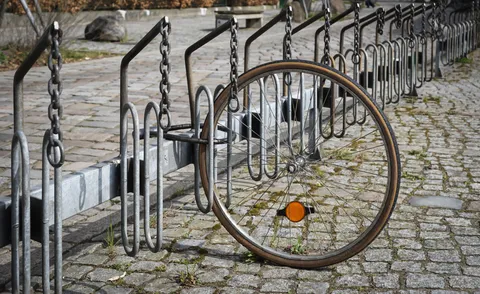 Das Vorderrad eines Fahrrads, angeschlossen an einem Fahrradständer